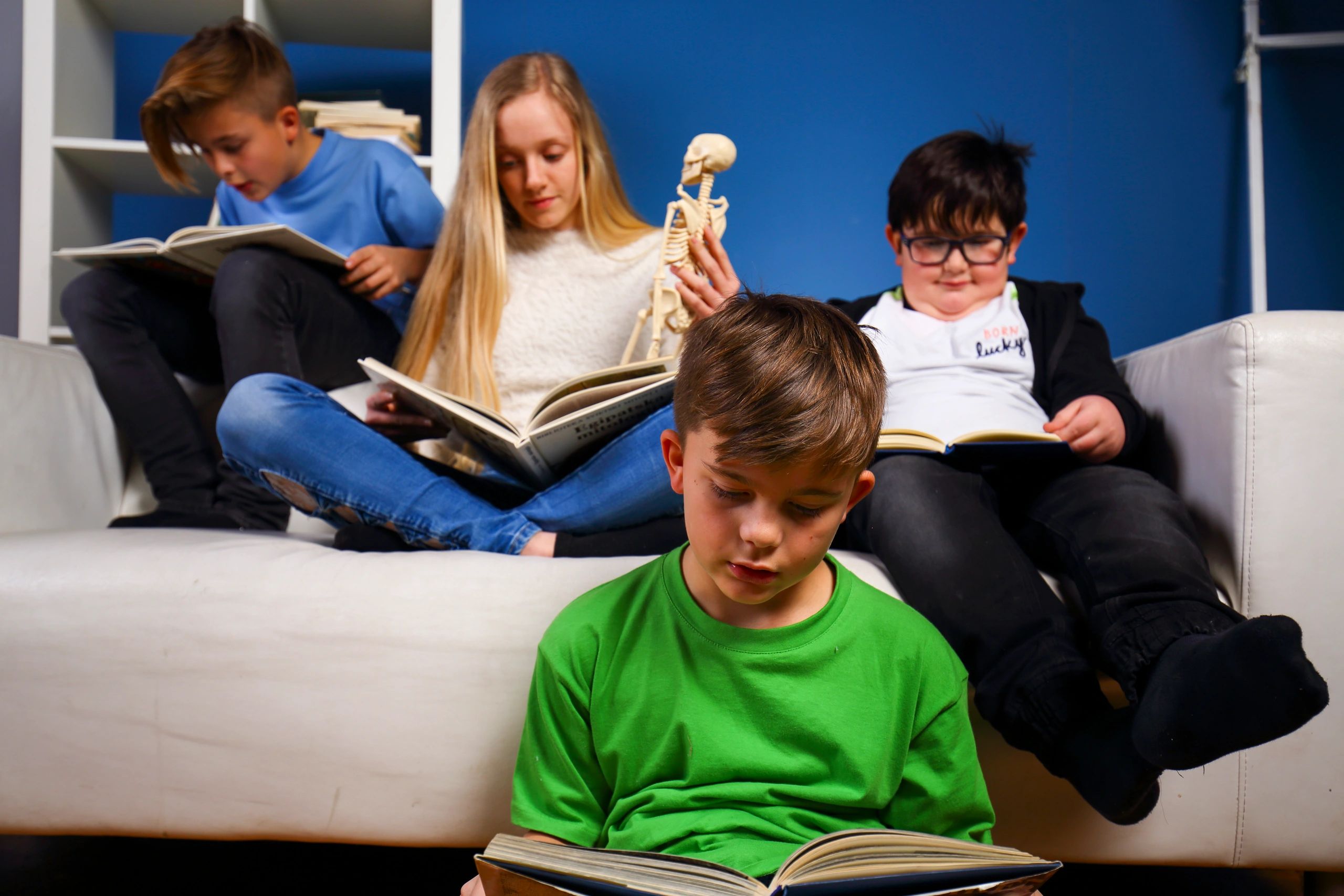 Children reading together on a couch