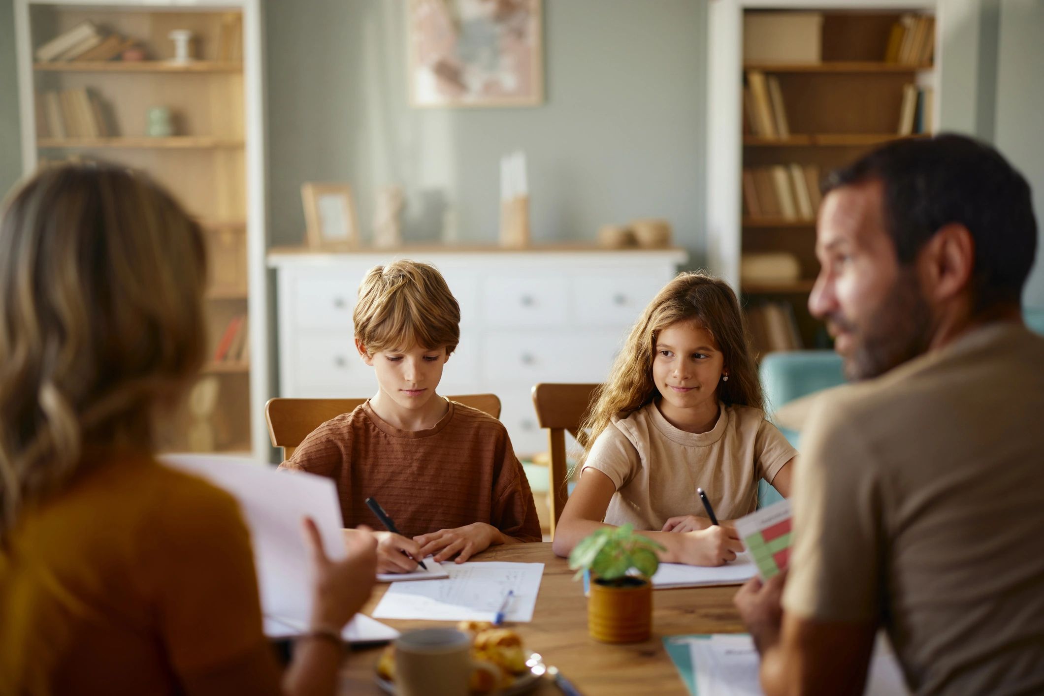Two young children studying with their parents during homeschooling