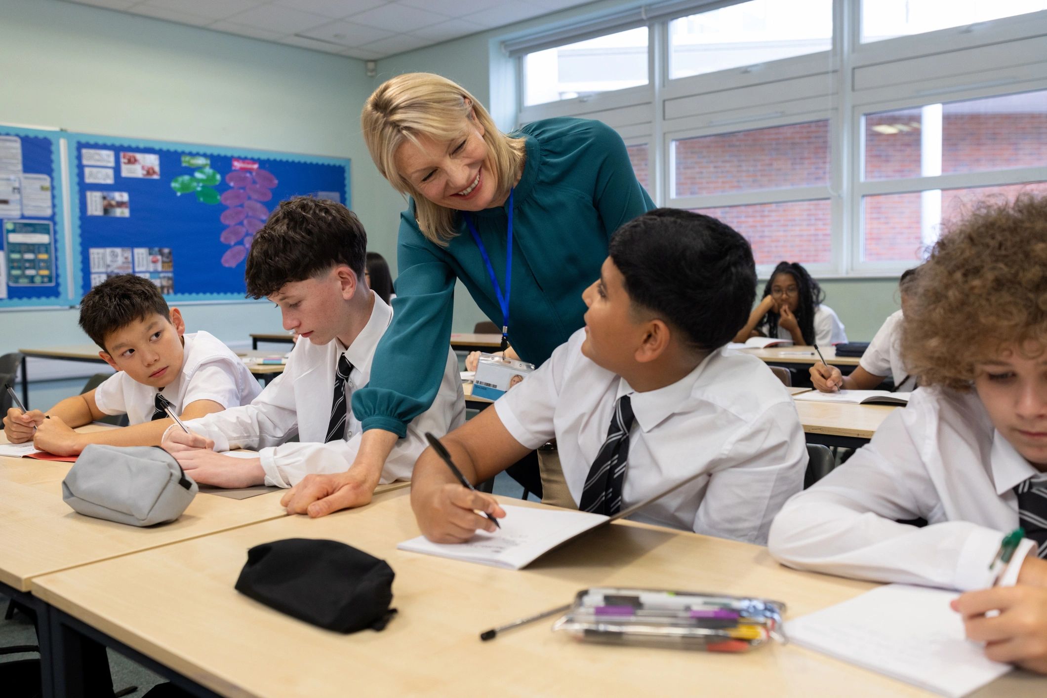 Teacher supporting young students in a bright classroom