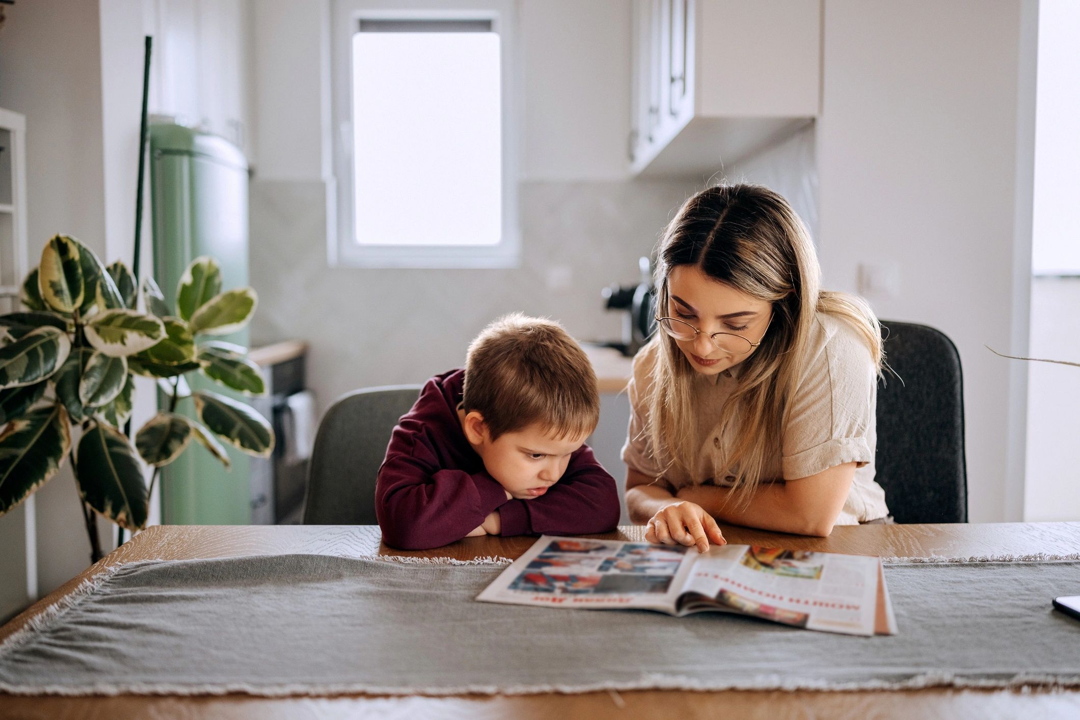 Parent and child reading together at a table